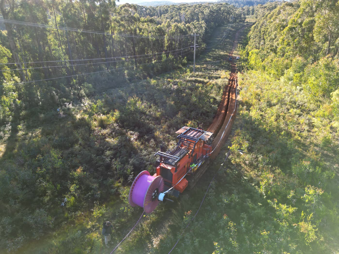 CFH Civils chain trencher with trailing fibre optic cable payout reel on a bush right-of-way