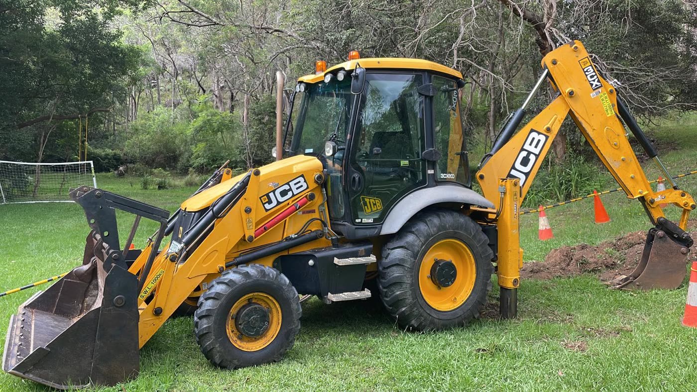 JCB backhoe loader set up with traffic cones on a CFH Civils excavation job